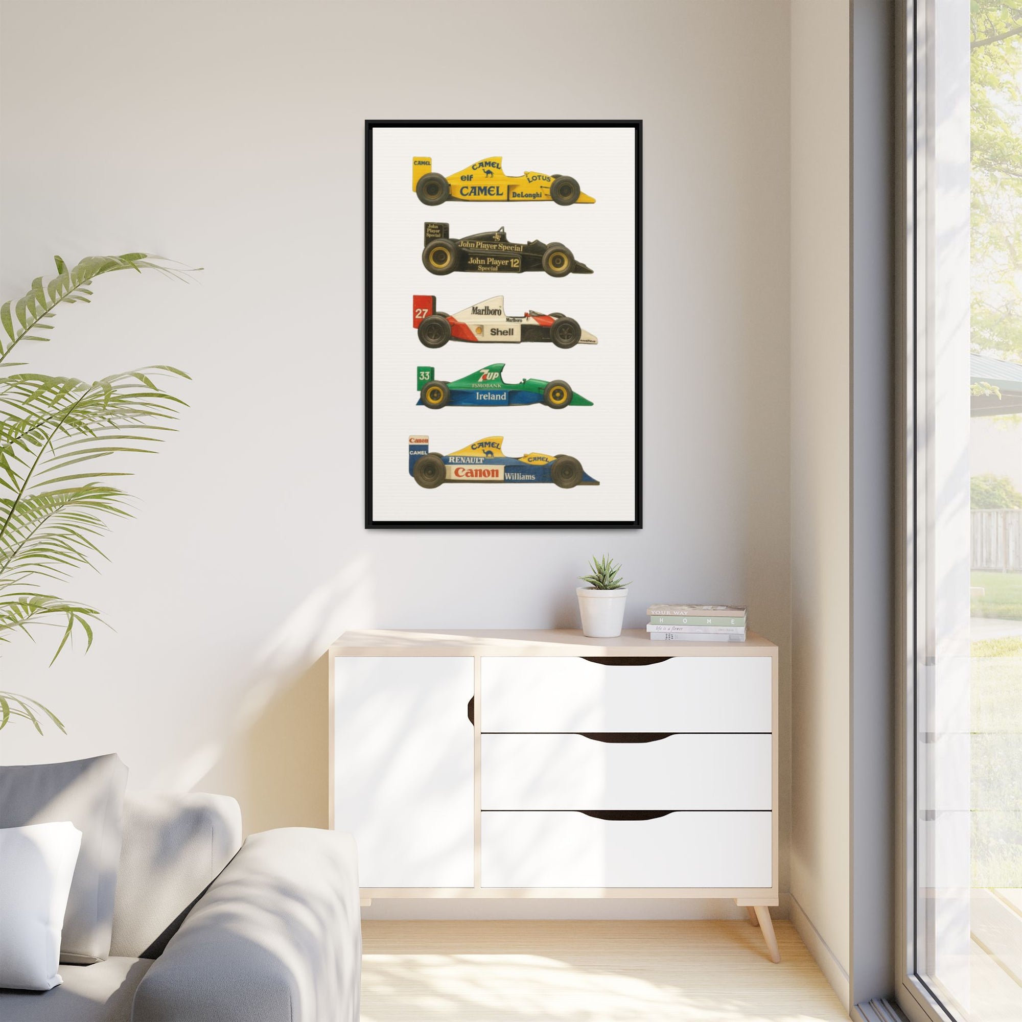 Framed poster of vintage racing cars on a wall above a white cabinet.