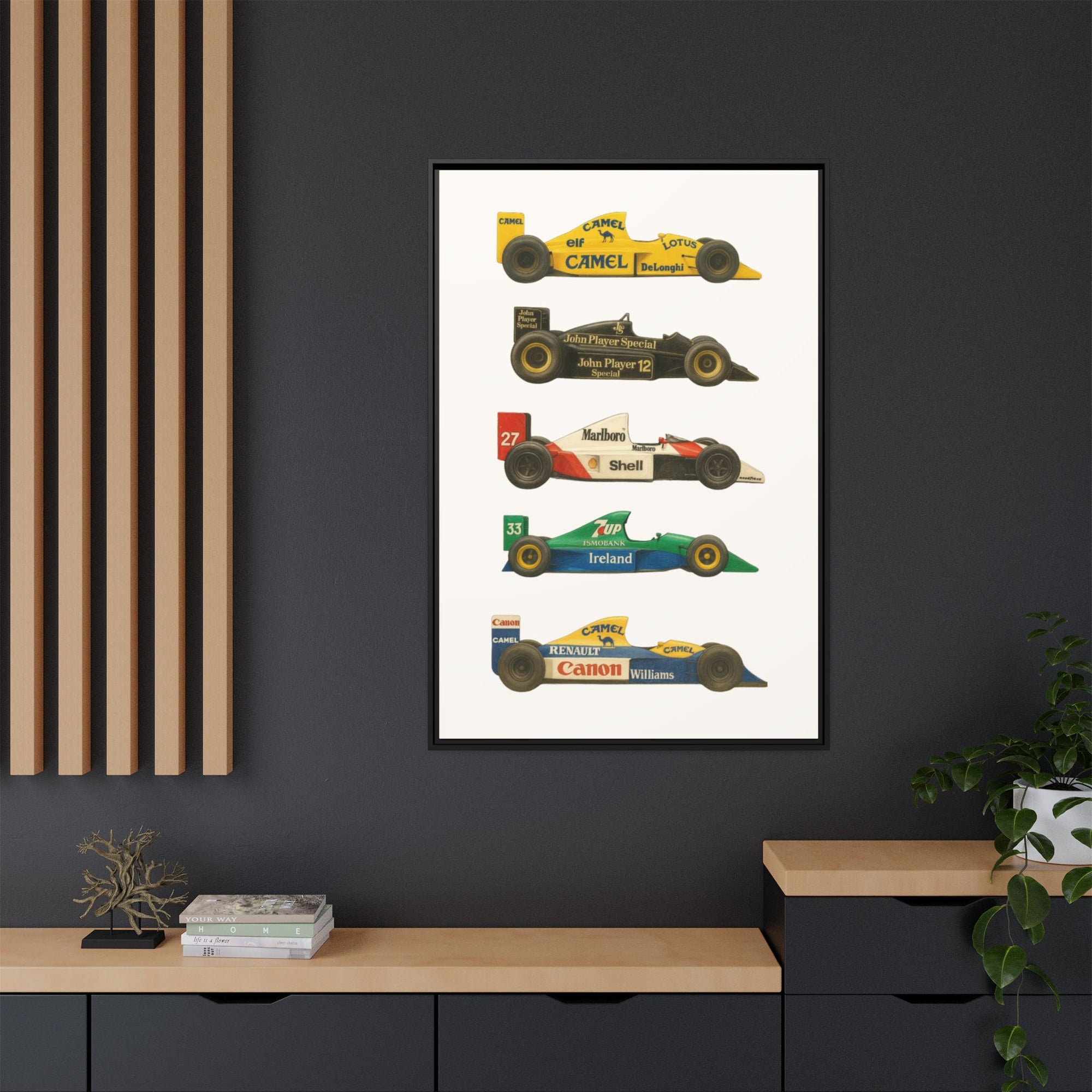 Framed poster of vintage Formula 1 cars on a dark wall with a wooden shelf below.