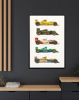 Framed poster of vintage Formula 1 cars on a dark wall with a wooden shelf below.